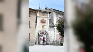 Mann auf Gravelbike fährt durch Tor von historischem Stadtkern