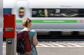 Person wartet an Bahngleis auf Zug