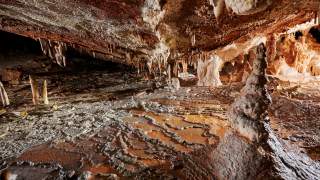 Im Inneren der Höhle sieht man Stalagmiten und Stalagtiten.