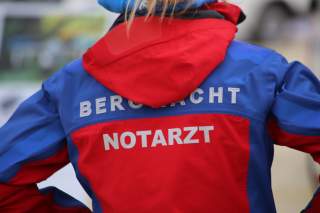 Die Rückenansicht einer rot-blauen Outdoorjacke mit der Aufschrift 