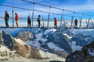 Hängebrücke in den Alpen, über die Menschen laufen