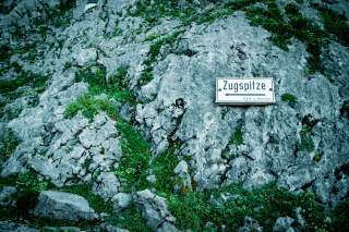 Schild in Felswand, das Richtung Zugspitze anzeigt