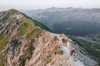 Mountainbiker auf einem Wanderweg auf einem Bergkamm.