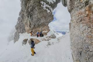 Einige Skibergsteiger am Felsenfenster des Monte Forato im Kanin-Gebiet; es liegt auf der Grenze Slowenien-Italien..