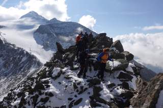 Gruppe von Bergsteigern auf ausgesetztem, schneebedecktem Grat