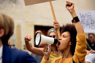 Frau ruft auf Demo in Megafon