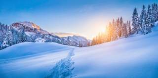 Winterlandschaft im Gebirge. Spur über eine tiefverschneite Wiese