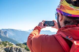 Mann nutzt Gipfelerkennungs-App am Berg